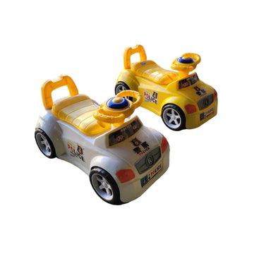 Two toy cars on a concrete surface with a car and store in the background.